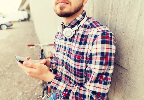 Csípő ember fülhallgató smartphone és kerékpár — Stock Fotó