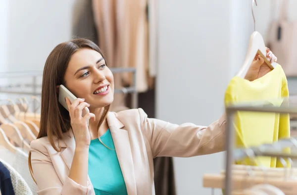 Kvinnan ringer på smartphone på klädaffär — Stockfoto