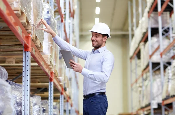 Glücklicher Geschäftsmann mit Tablet-PC im Lager — Stockfoto