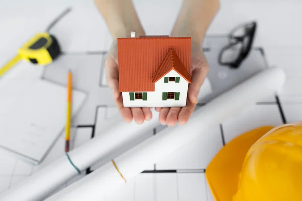 Close up of hands with house model above blueprint — Stock Photo, Image