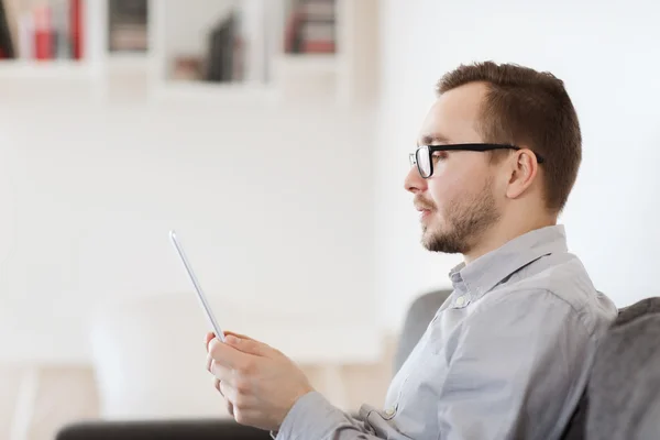 Lächelnder Mann, der zu Hause mit Tablet-PC arbeitet — Stockfoto