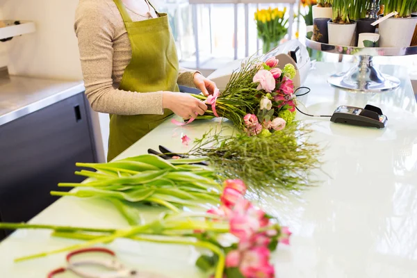 Крупним планом жінка робить букет в квітковому магазині — стокове фото