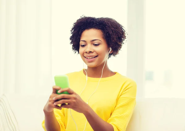 Happy african woman with smartphone and earphones — Stock Photo, Image
