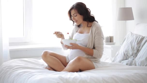 Mujer embarazada comiendo ensalada en la cama en casa 1 — Vídeo de stock