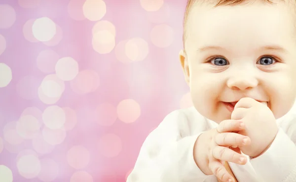 Bebê feliz sobre luzes rosa fundo — Fotografia de Stock