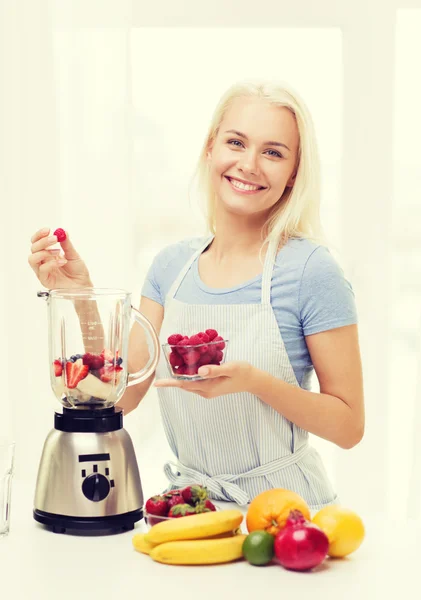 Mujer sonriente con licuadora preparando batido en casa —  Fotos de Stock