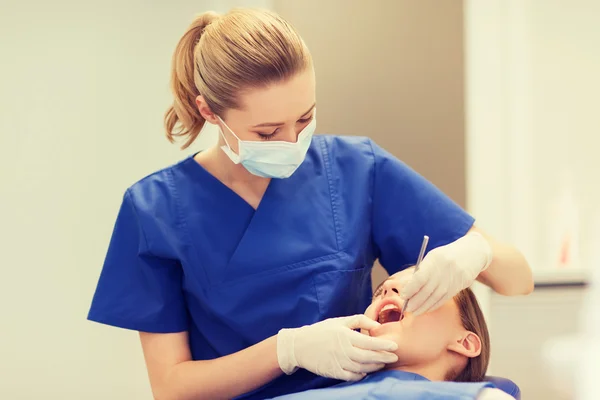 Dentista feminino verificando os dentes da menina paciente — Fotografia de Stock