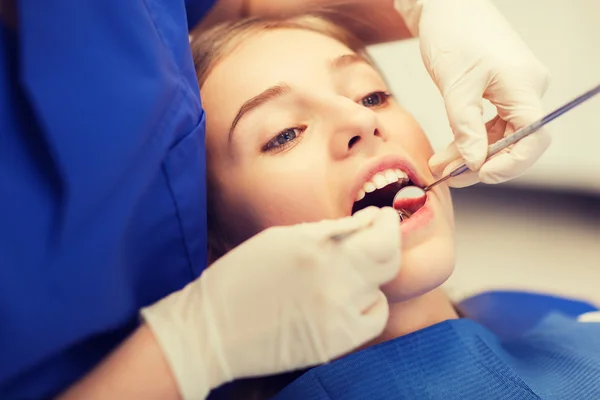 Dentista femenino chequeando dientes de niña paciente — Foto de Stock