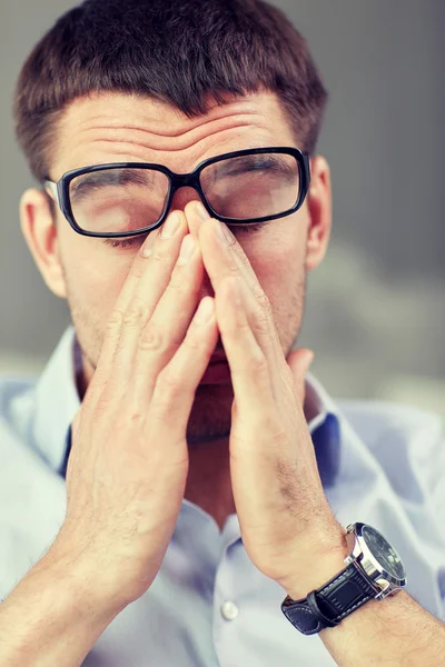 Hombre de negocios cansado con anteojos en la oficina — Foto de Stock