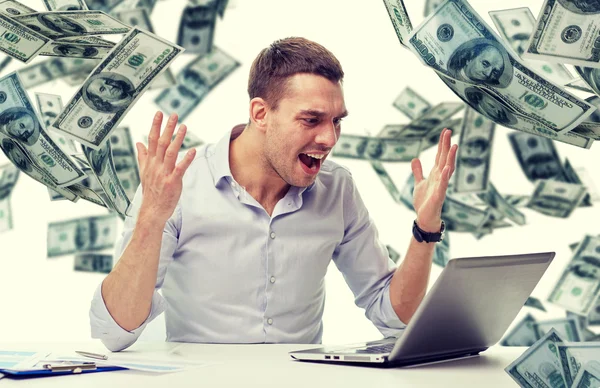 Boos zakenman met laptop en dalende geld — Stockfoto