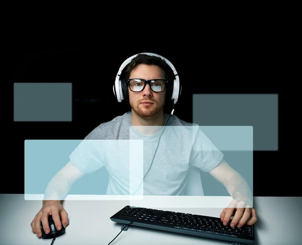 Hombre en auriculares jugando videojuego de ordenador — Foto de Stock