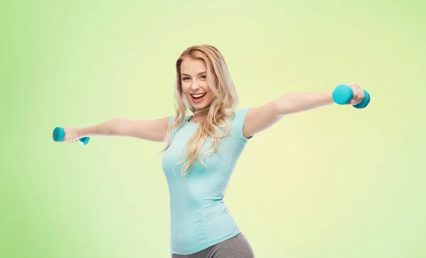 Sorridente bella giovane donna sportiva con manubri — Foto Stock