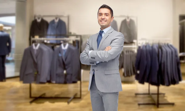 Hombre de negocios feliz en traje sobre tienda de ropa —  Fotos de Stock