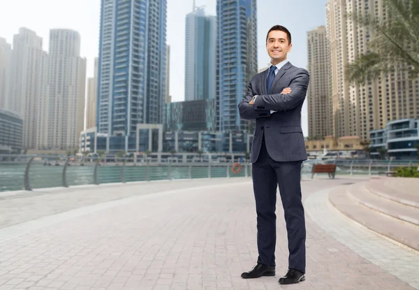 Happy smiling businessman in suit over dubai city — Stock Photo, Image
