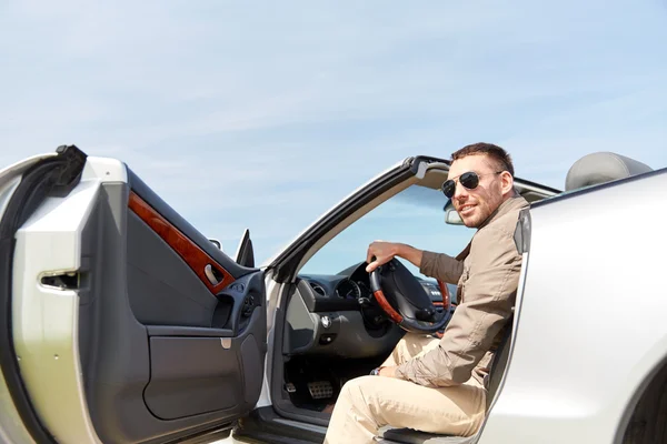 Hombre feliz abriendo la puerta de cabriolet coche al aire libre — Foto de Stock