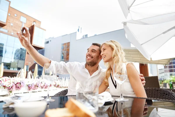Par med selfie med smatphone på restaurang — Stockfoto