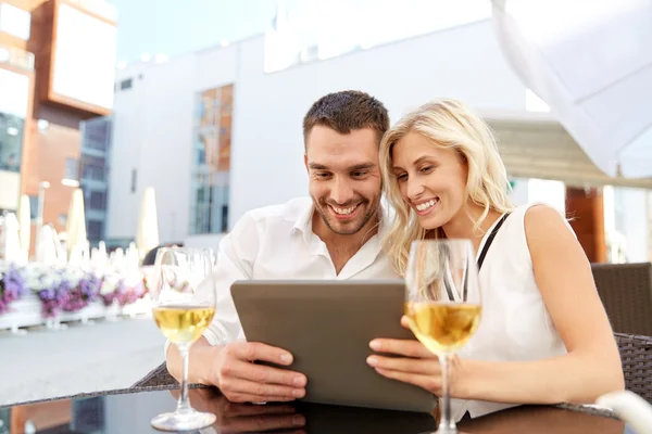 Gelukkige paar met de tablet pc bij terras restaurant — Stockfoto