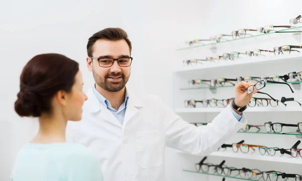 Frau und Optikerin zeigen Brille im Optikgeschäft — Stockfoto