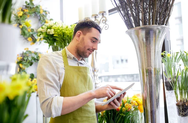 Man with tablet pc computer at flower shop — Stock Photo, Image