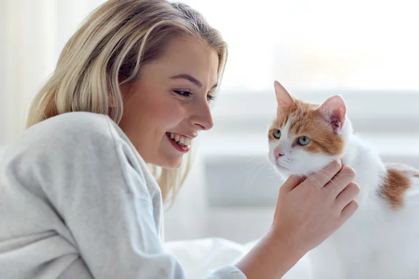 幸福的年轻女人，与猫在家里的床上 — 图库照片