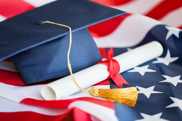 Bachelor hat and diploma on american flag — Stock Photo, Image
