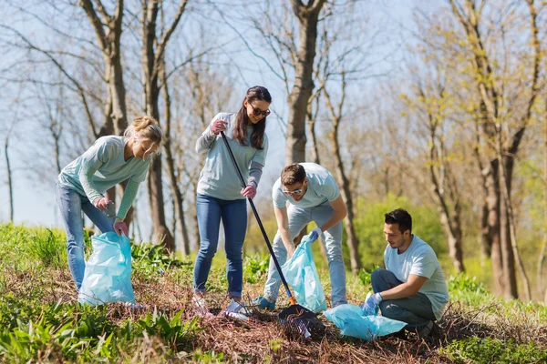 Freiwillige mit Müllsäcken säubern Parkfläche — Stockfoto