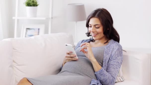 Mujer embarazada feliz con teléfono inteligente en casa — Vídeos de Stock