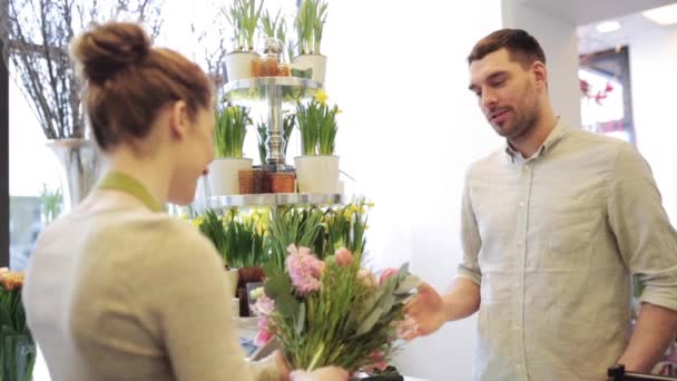 Floristería mujer con flores y hombre en floristería — Vídeo de stock