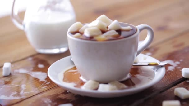 Taza de café llena de azúcar en masa en la mesa de madera — Vídeo de stock