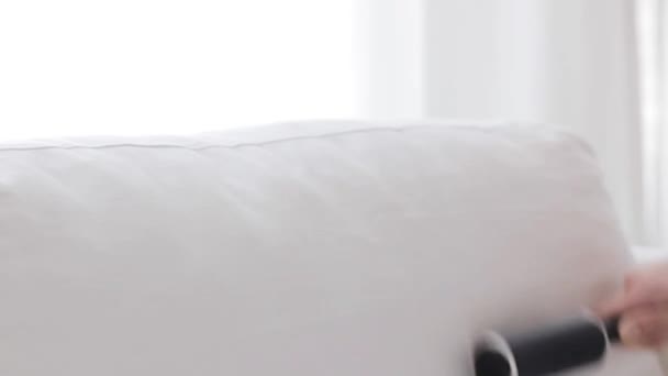 Mulher com estofos pegajosos do sofá da limpeza do rolo — Vídeo de Stock