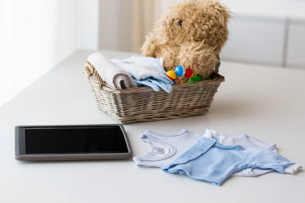 Close up van babykleding, speelgoed en tablet pc — Stockfoto