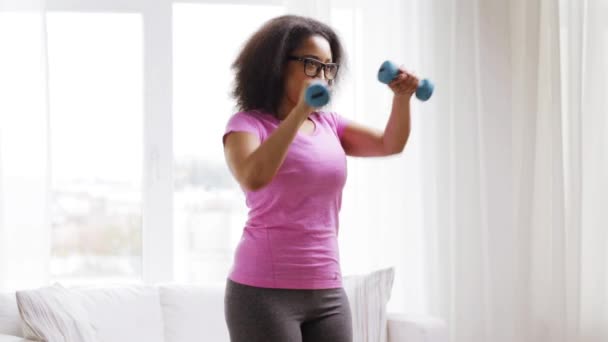Mujer africana haciendo ejercicio con pesas en casa — Vídeos de Stock