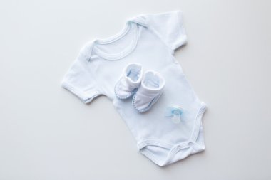 close up of baby boys clothes for newborn on table clipart