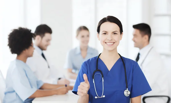 Zufriedener Arzt über Gruppe von Sanitätern im Krankenhaus — Stockfoto