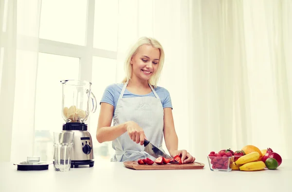 Mulher sorridente com liquidificador preparando shake em casa — Fotografia de Stock