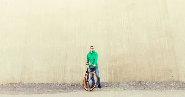 Χαρούμενος νεαρός hipster άνθρωπος με ποδήλατο στάσιμου — Φωτογραφία Αρχείου