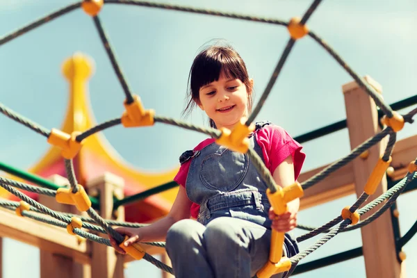 Fröhliches kleines Mädchen klettert auf Kinderspielplatz — Stockfoto