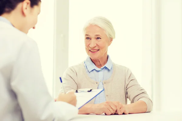 Médecin avec presse-papiers et femme âgée à l'hôpital — Photo