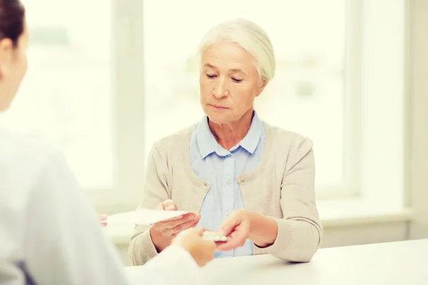 Médico que da prescripción y medicamento a la mujer —  Fotos de Stock