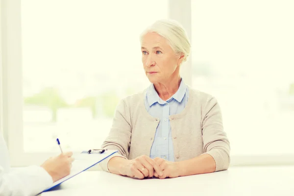 Arzt mit Klemmbrett und Seniorin im Krankenhaus — Stockfoto