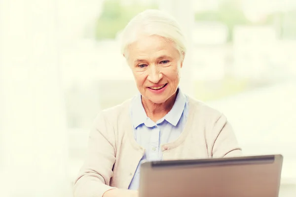 Mujer mayor feliz con el ordenador portátil en casa — Foto de Stock