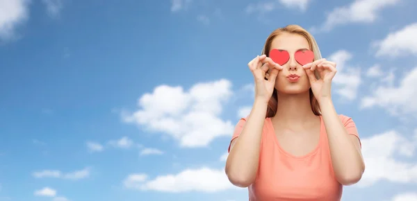 Gelukkig jonge vrouw met rood hart shapes op ogen — Stockfoto