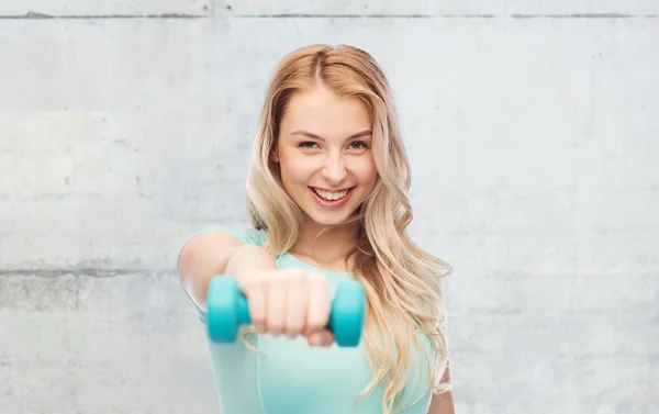 Sorrindo bela jovem mulher esportiva com haltere — Fotografia de Stock