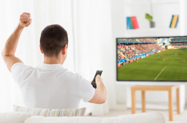 Homem feliz assistindo futebol ou jogo de futebol na tv — Fotografia de Stock