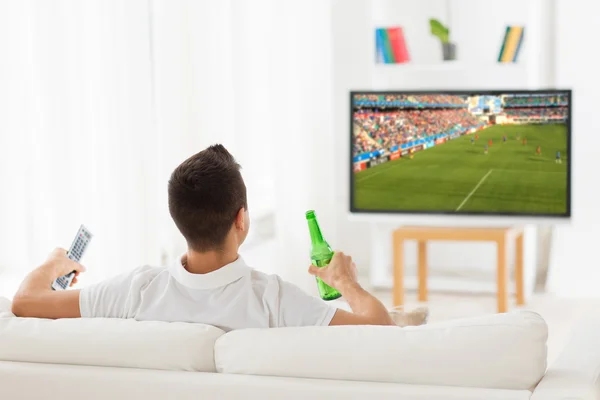 Ο άνθρωπος που παρακολουθούν ποδόσφαιρο παιχνίδι στην τηλεόραση και πίνοντας μπύρα — Φωτογραφία Αρχείου