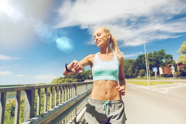 Smiling young woman running outdoors — Stock Photo, Image