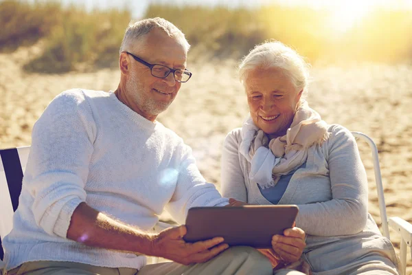 Gelukkige senior paar met de tablet pc op zomer strand — Stockfoto