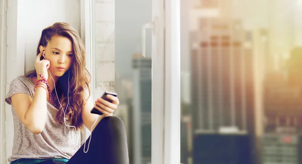 Menina adolescente com smartphone e fones de ouvido — Fotografia de Stock