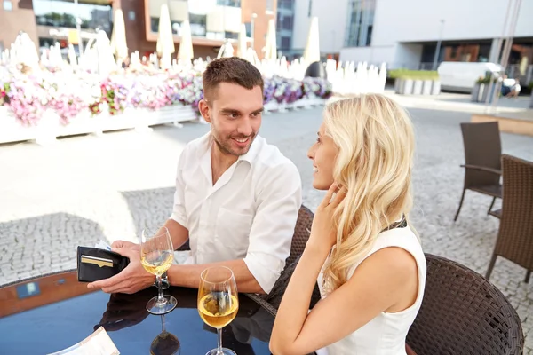 Happy couple with wallet paying bill at restaurant — Stock Photo, Image