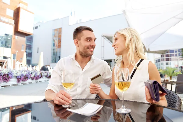 Happy couple with wallet paying bill at restaurant — Stock Photo, Image